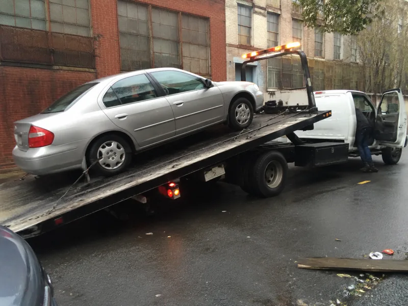 Flatbed tow truck loading a car in Newark NJ